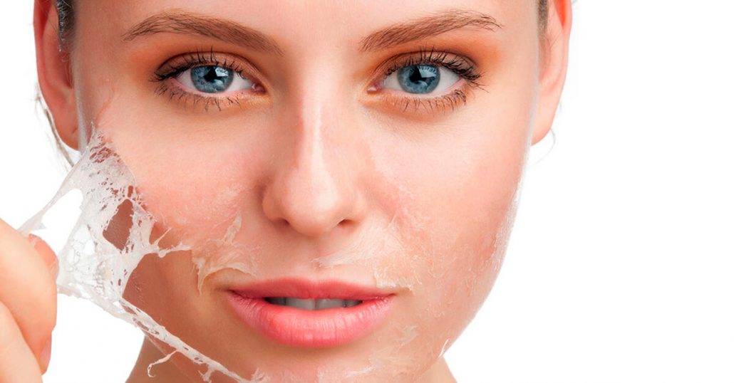 Femme appliquant un masque facial exfoliant.